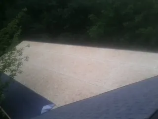 New OSB roof sheathing installed beside an existing shingle roof in Oskaloosa